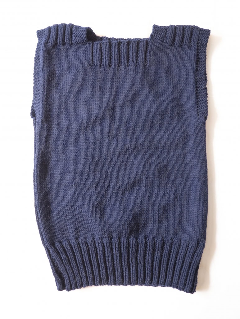 Sleeveless sweater knit by the author using the Red Cross pattern ARC 400-3. Knit on US size 8 in worsted weight wool (Quince & Co Lark in Navy)