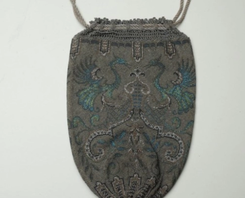 Knitted, beaded, drawstring handbag with rampant peacock design.