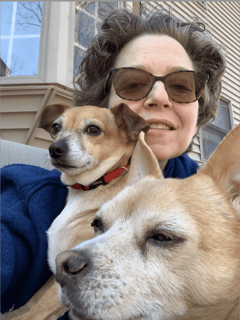 Lori wearing sunglasses with her two dogs