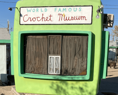 A green building with the words World Famous Crochet Museum