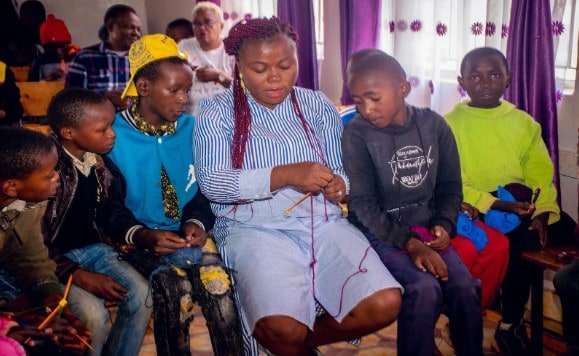 Okeyele Olatunji 1 Elizabeth teaches a group of boys to knit at the KAG Bethel Children's Home. Courtesy of Elizabeth Okeyele-Olatunji