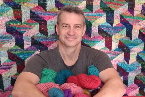 Kirk Dunn with several skeins of yarn
