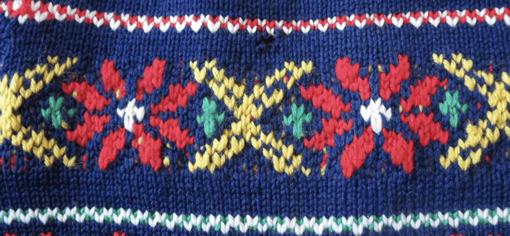 A knit pattern of yellow and red on a blue background