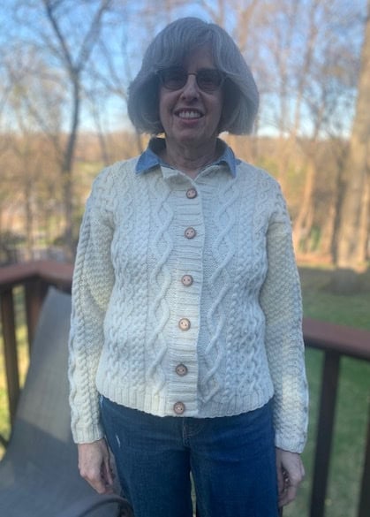 A knitted, cabled cardigan is modeled by designer and maker Stephanie Lieberman Paley. It features various cable designs and buttons from Iceland.