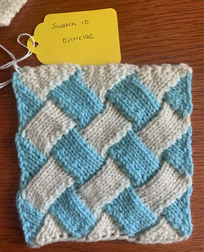 A swatch in the entrelac technique, which gives the impression of light blue and white knitted strips woven together.